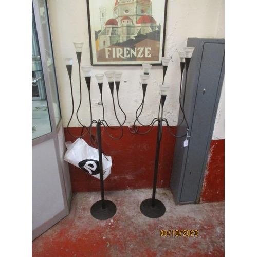 161 - A pair of wrought metal floor standing six branch candle stands