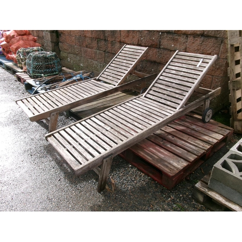 21 - A pair of teak sun loungers (one with damaged slat)