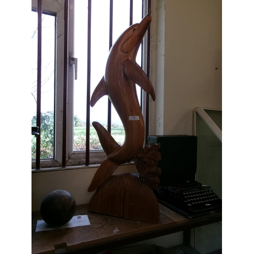 110 - A wooden carving of a dolphin of large proportion