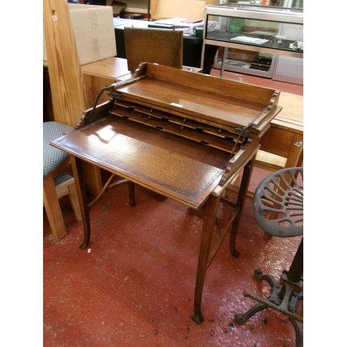 237 - A hard wood writing desk with mechanical opening mechanism to reveal a brown gilded and tooled leath... 