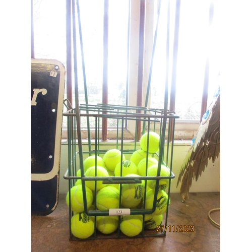 123 - A quantity of tennis balls contained within a wrought metal basket