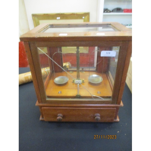 319 - A set of chemist's vintage scales enclosed within a glazed mahogany cabinet