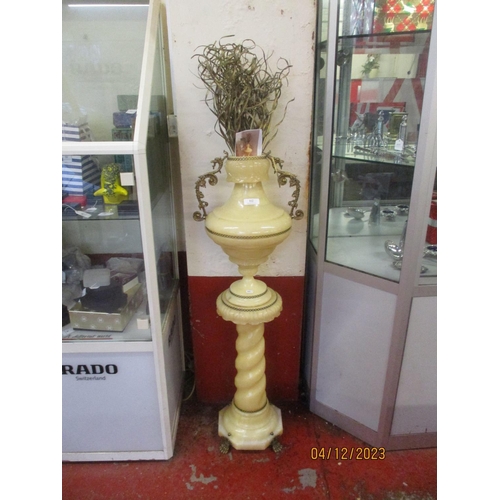 112 - An alabaster vase set upon a barley twist stand with profuse gilded decoration