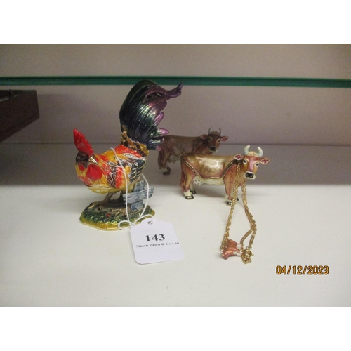 143 - Two enamel trinket boxes modelled as Jersey cows together with another of a cockerel