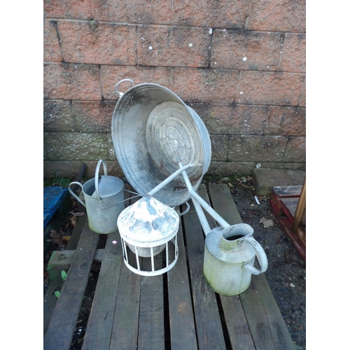 22 - A vintage galvanised wash tin, two watering cans and poultry feeders