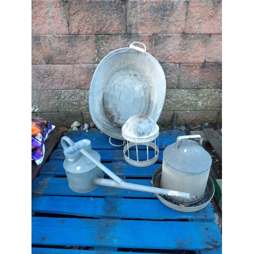 23 - A vintage galvanised wash tin, poultry feeders and waterers and a watering can