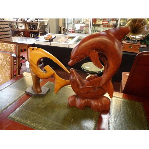 341 - A wooden sculpture of two dolphins together with one other of a fish