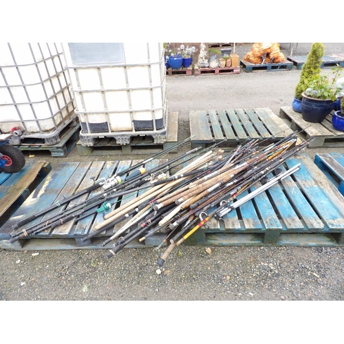 28 - A large and diverse assortment of fishing rods together with flat fish spikes, reels etc.