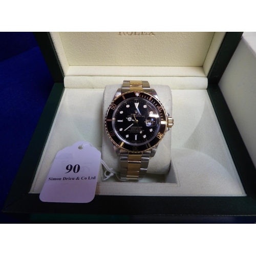 90 - A Rolex Oyster Perpetual Date Submariner wrist watch on stainless steel and gold bracelet strap