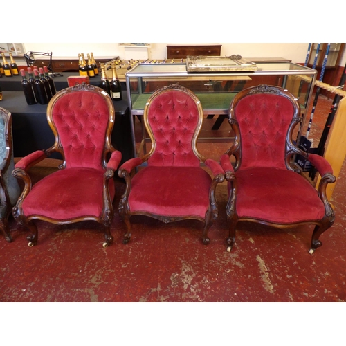 228 - A harlequin set of three Victorian mahogany spoon back open armchairs upholstered in deep red colour... 