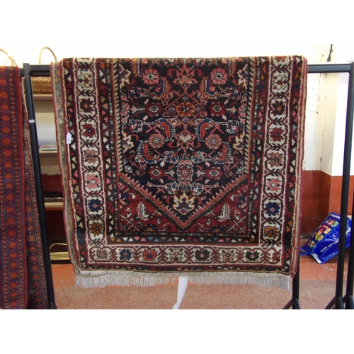 240 - An oriental carpet runner decorated with geometric designs on a deep red coloured ground