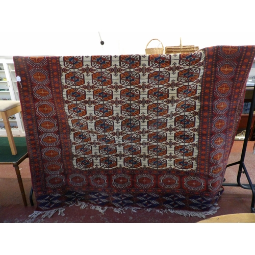 241 - An oriental carpet decorated with geometric designs on a red and neutral coloured ground