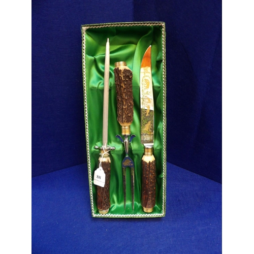 88 - A boxed three piece carving set with antelope handles by Solingen of Germany