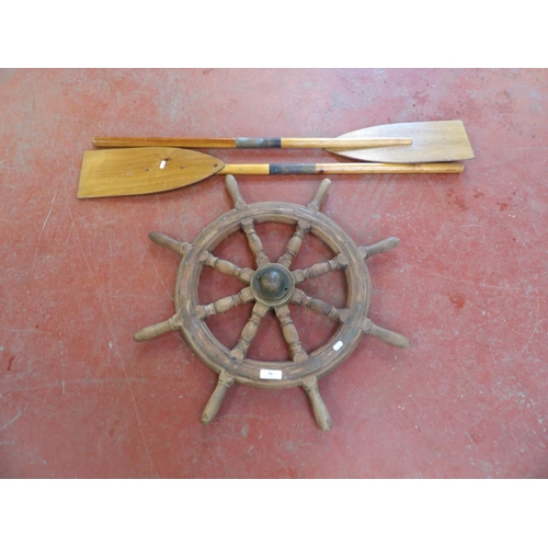 96 - A brass mounted mahogany ship's wheel together with a pair of vintage paddles