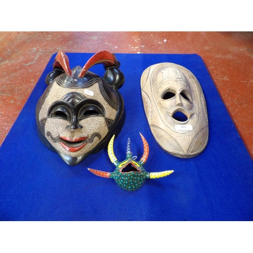 192 - Two tribal wall masks together with one other