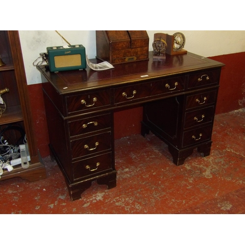 392 - A mahogany twin pedestal desk the top inlaid with burgundy coloured gilded and tooled leather