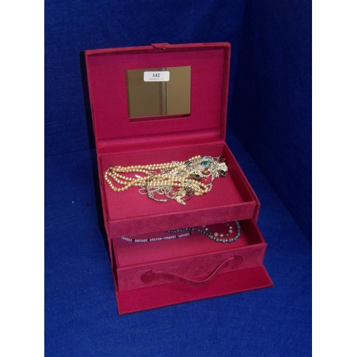 142 - A faux suede jewellery chest containing an accumulation of jewellery