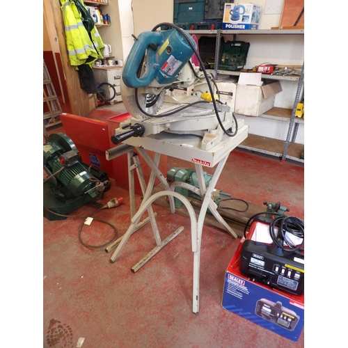 83 - A Makita LS1013 110 volt compound mitre saw, stand and roller stand