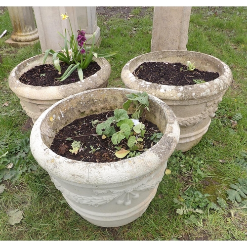 20 - A set of three reconstituted stone circular planters with garland and fruit decoration