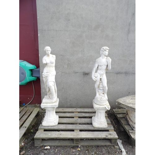 49 - A pair of reconstituted stone statues depicting a classical nude couple on plinths