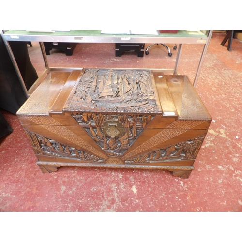 A vintage Chinese camphor wood trunk with profuse carved decoration