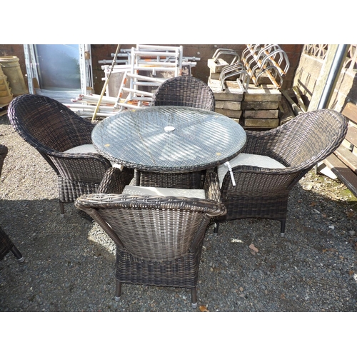 25 - An all weather rattan circular patio table together with four matching chairs