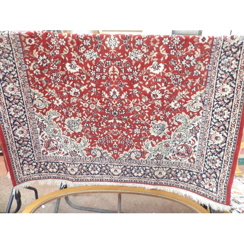 363 - An oriental floor rug on red coloured ground with floral decoration