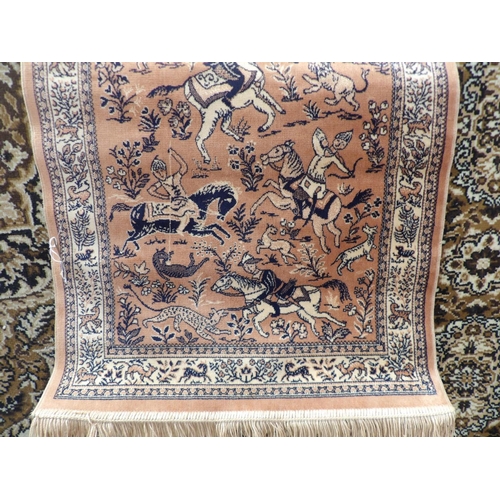 364 - An oriental floor rug decorated with a hunting scene on salmon coloured ground