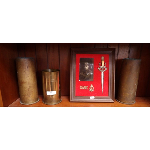 495 - Three brass ammunition shell cases together with a frame of trench art and a photograph