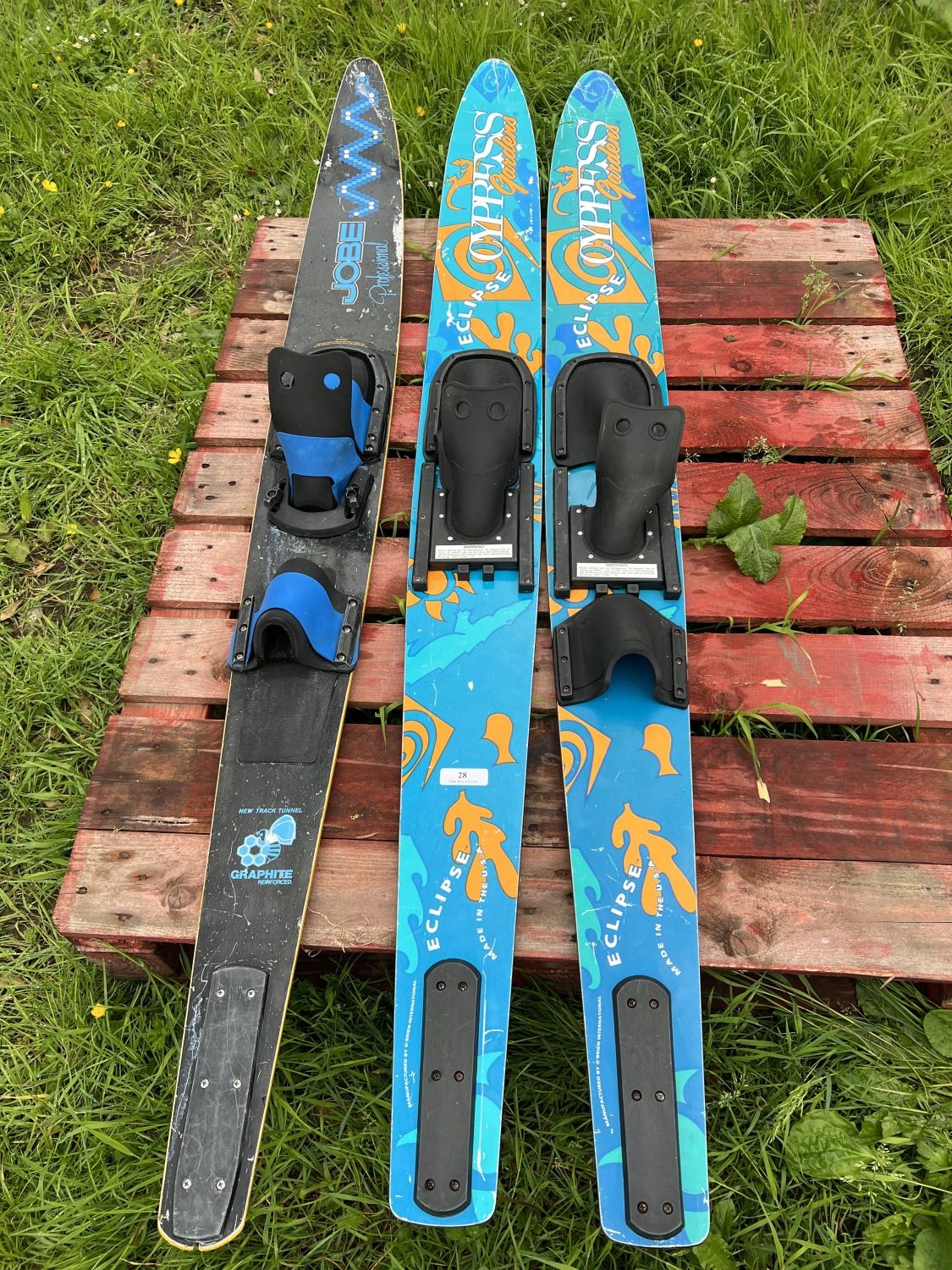 A pair of water skis together with a mono water ski