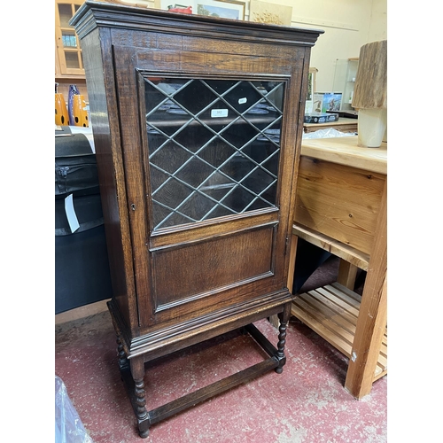 352 - An early twentieth century lead glazed oak cabinet