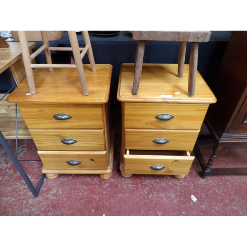 394 - A pair of honey glazed pine three drawer bedside chests