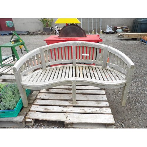 119 - A teak garden bench of curved form