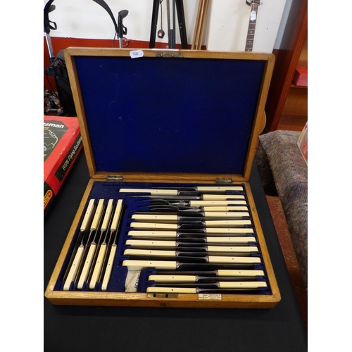 249 - A vintage oak canteen of bone handled cutlery and a carving set by Messrs. Walker & Hall