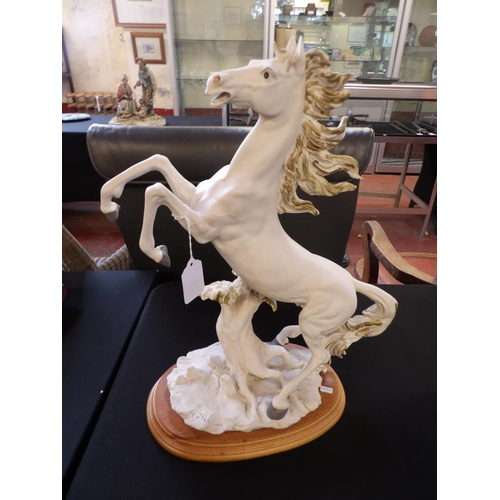 277 - A porcelain model of a prancing horse on plinth