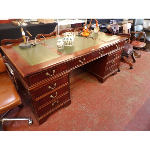 302 - A substantial mahogany twin pedestal desk the top inlaid with green gilded and tooled leather