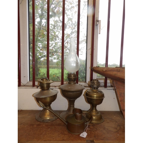 140 - Three vintage paraffin oil lamps together with an ornamental watering can