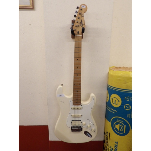 242 - A Squier Stratocaster by Fender electric guitar together with a Line 6 amplifier