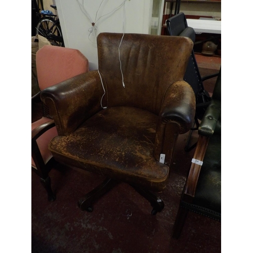 296 - A vintage revolving study chair upholstered in brown coloured leather