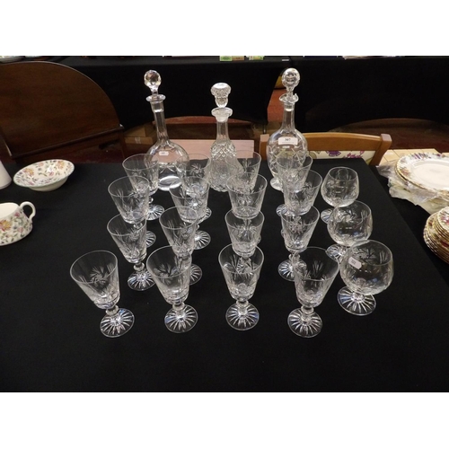 307 - A range of crystal drinking glasses together with three decanters