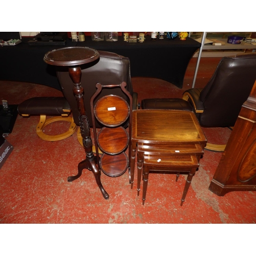 340 - A graduated nest of three mahogany occasional tables, a folding cake stand and a plant stand