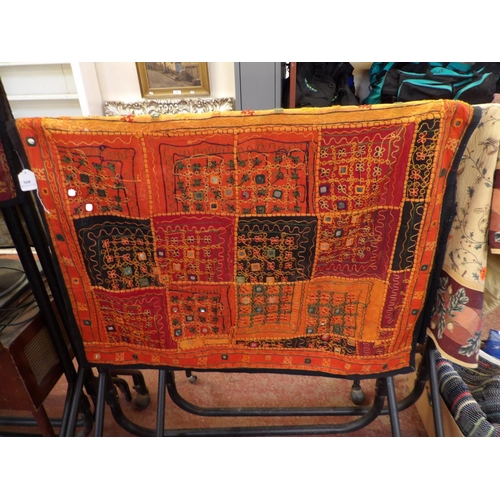 368 - A floor rug with mirrored and squared designs on an orange coloured ground and modelled in the Asian... 