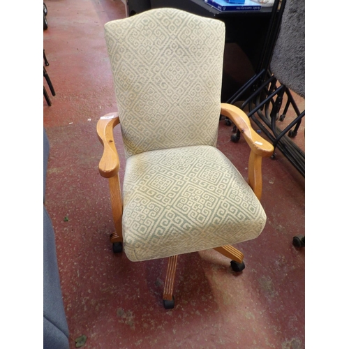 336 - A pine framed revolving open armchair upholstered in diamond design fabric