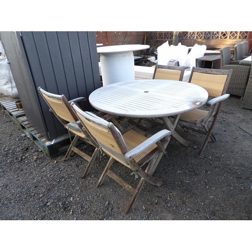 28 - A circular teak garden table together with four matching teak and rattan folding chairs