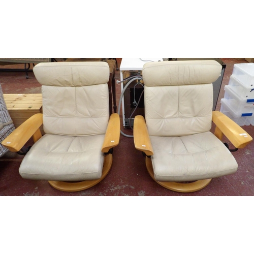 225 - A pair of Stressless beech framed revolving adjustable armchairs upholstered in cream coloured leath... 