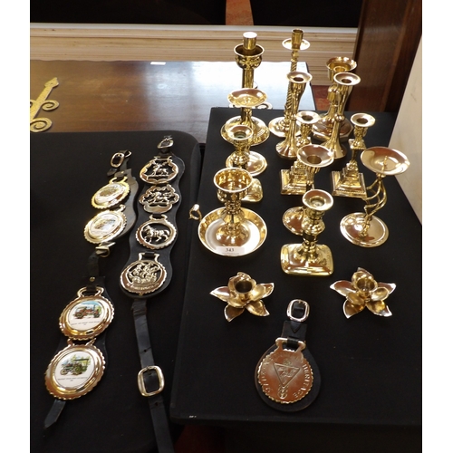 343 - A collection of brass candle stick holders together with four Martingales and horse brasses