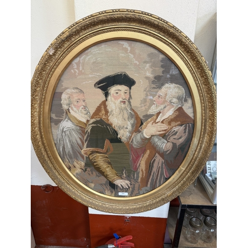 209 - A vintage gilt framed wool work depicting three learned gentlemen