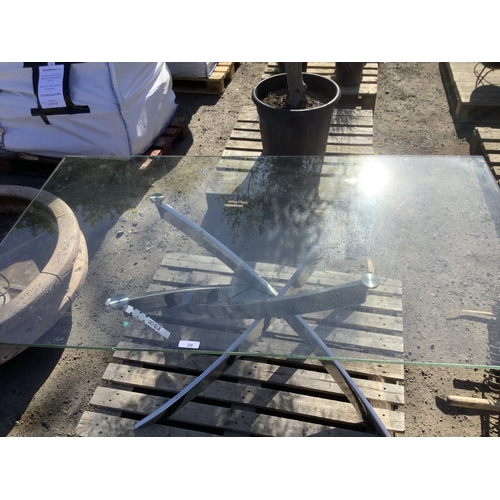 38 - A contemporary glass top stainless steel patio table