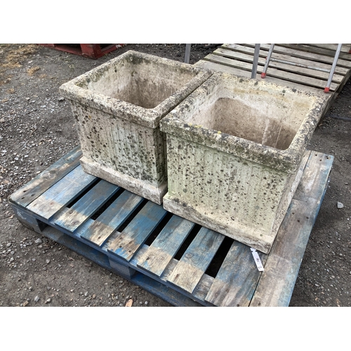 100 - A pair of reconstituted stone planters of square form with fluted decoration