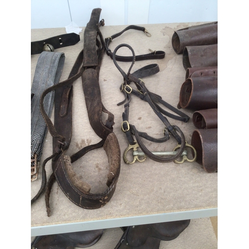 82 - A selection of riding items including bridles and girths